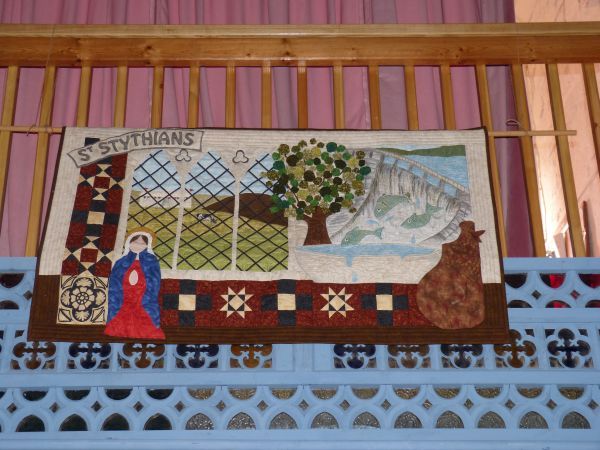 Blijkbaar sta ik als toeschouwer aan de binnenkant van de kerk, waar Stithian - te oordelen naar haar gevouwen handen - een biddend leven lijdt. Door de ramen zie ik buiten de middelen van bestaan: veeteelt, visvangst en boomkwekerijen.